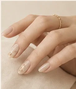 A hand with a slim gold ring and fine nail detailing