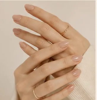 Folded hands with soft, glossy nude nails