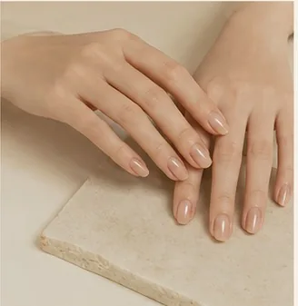 Hands resting flat on stone, showing natural-tone nails